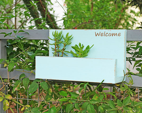 wooden welcome sign and planter
